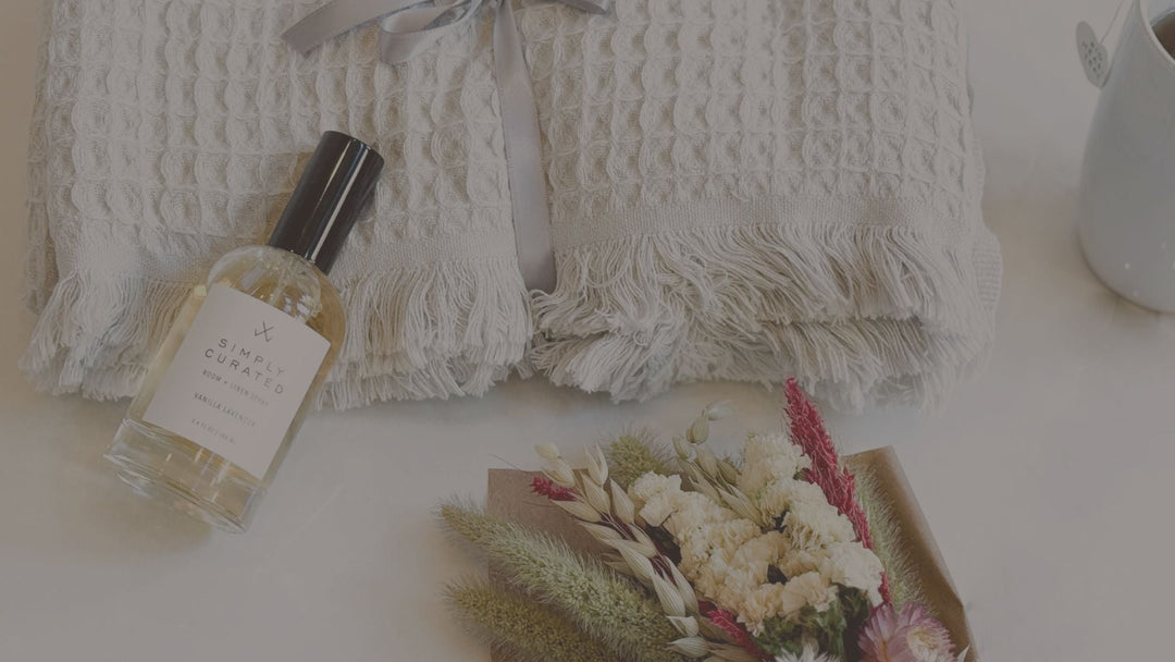 essential oil and dried flowers laid down with a throw blanket