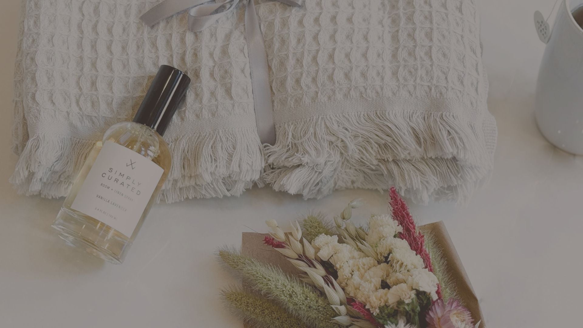 essential oil and dried flowers laid down with a throw blanket