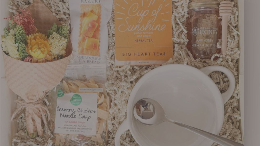 A care and sympathy gift box with soup and flowers in it