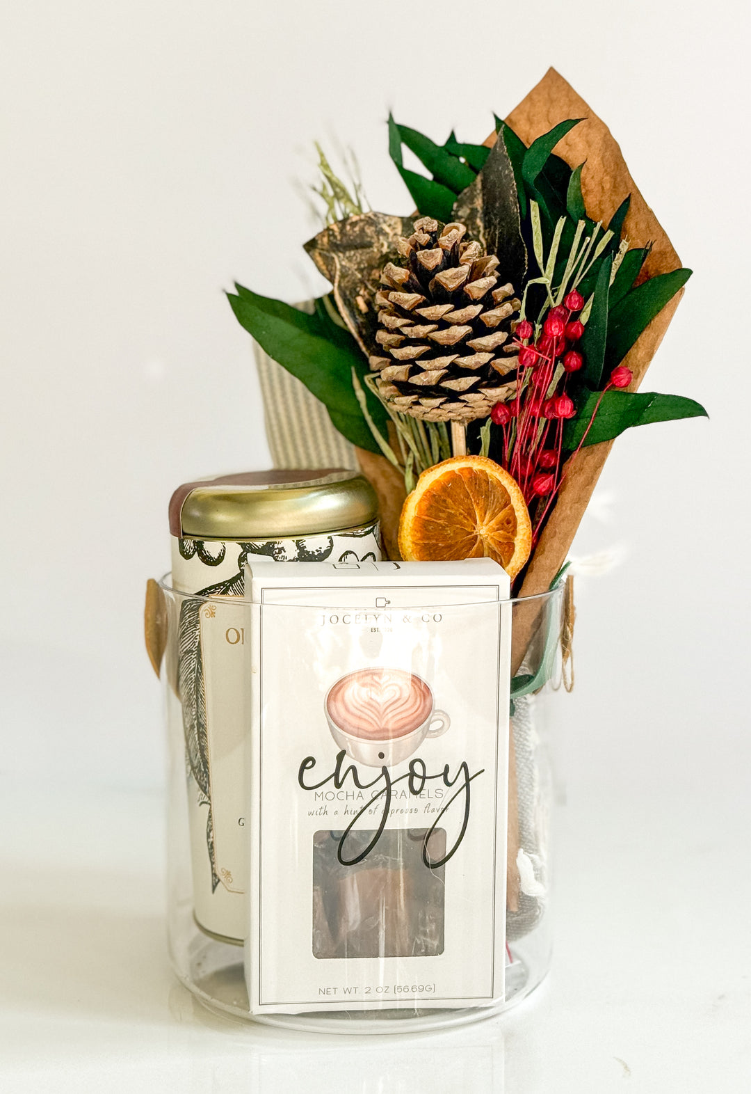 Coffee, caramels, hand towel and bouquet in a glass jar with decorative elements on a white background