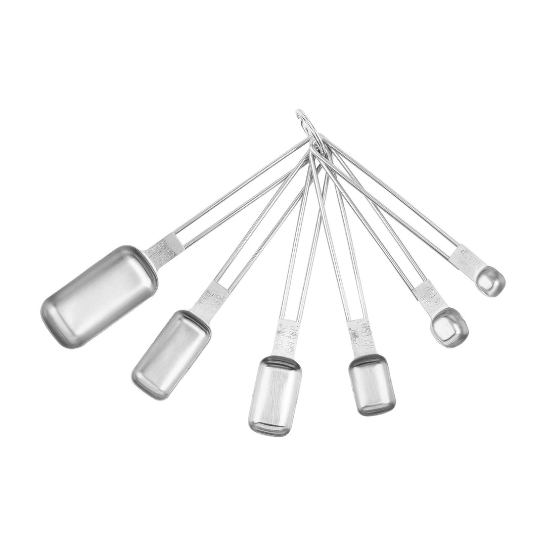 Various sizes of stainless steel measuring spoons connected by a ring on a white background. 
