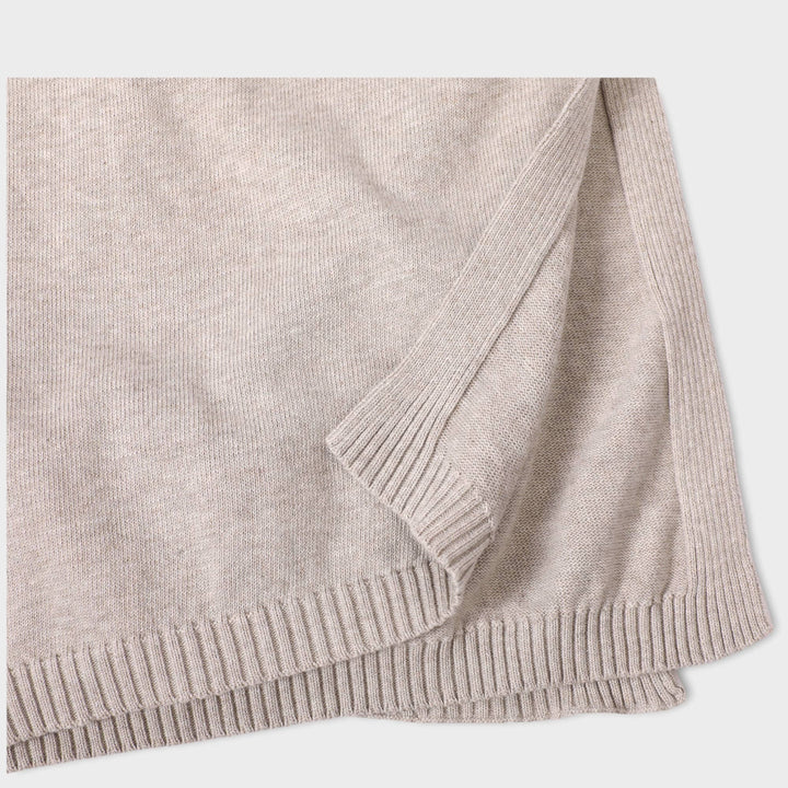 Beige knitted blanket on a light gray background