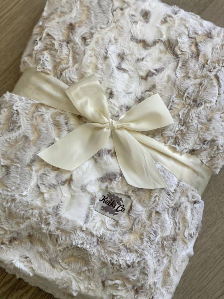 Soft, furry throw blanket with a bow and &