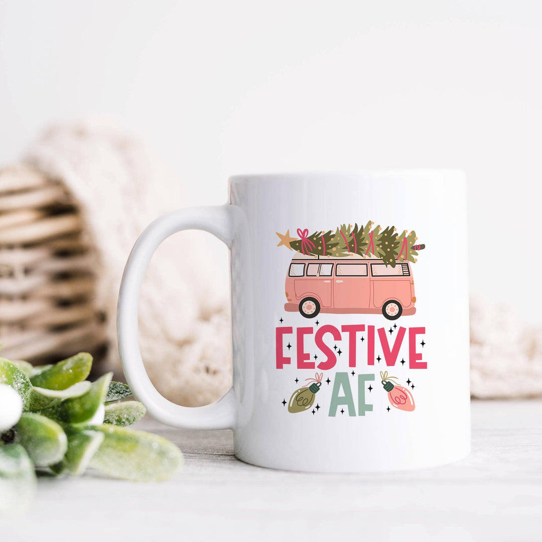 White mug with Christmas-themed design featuring a pink van and &