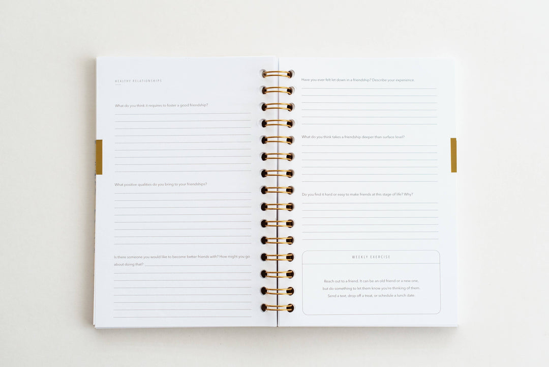 Open planner with gold binding on a white background