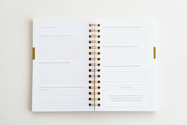 Open planner with gold binding on a white background