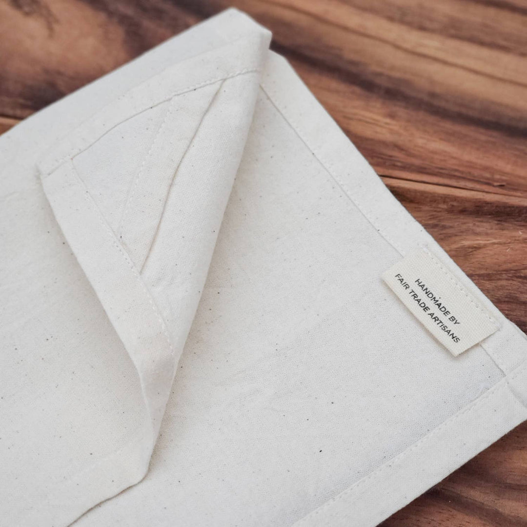 Close-up of a folded beige fabric with a label on a wooden surface