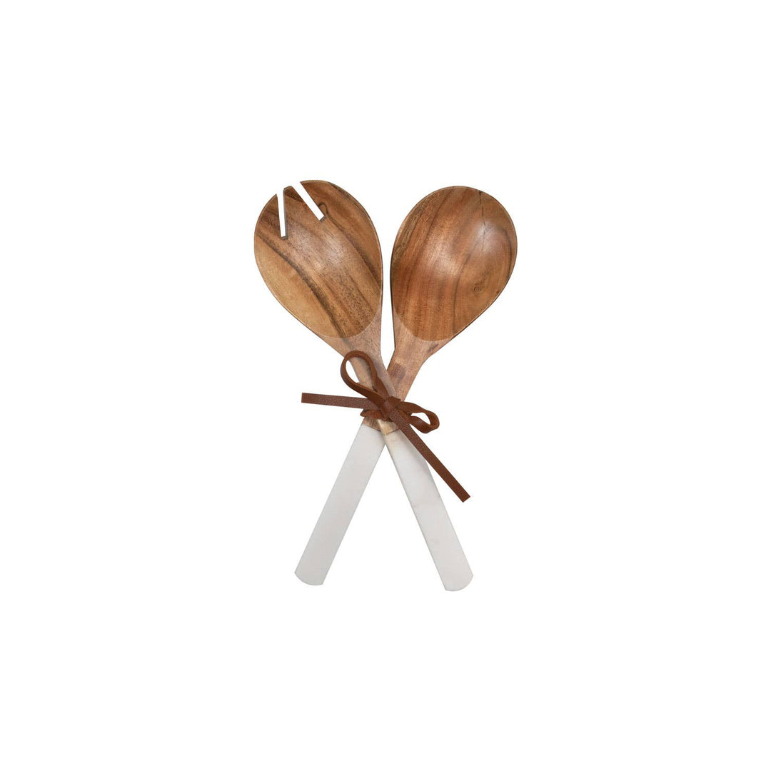 Two wooden and marble spoons tied together with a ribbon on a white background