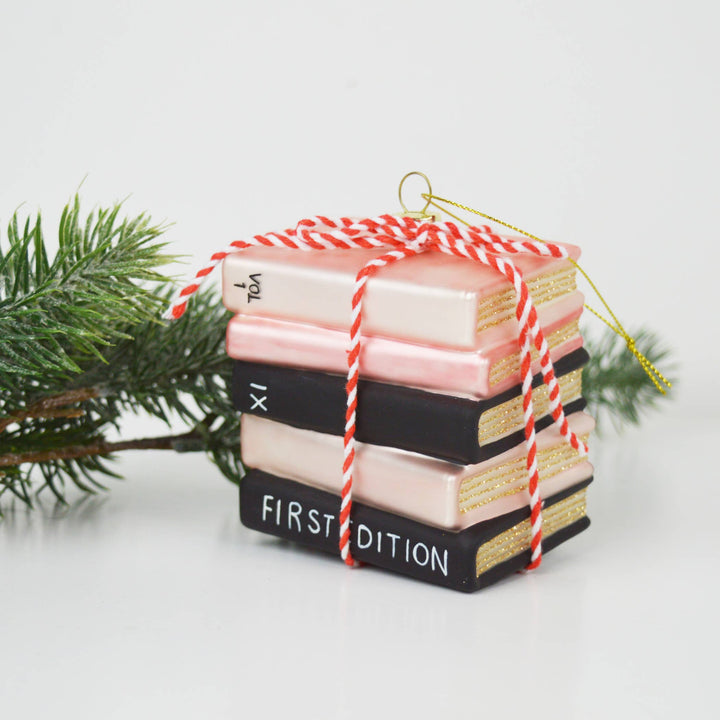 Stack of books ornament tied with string against a white background