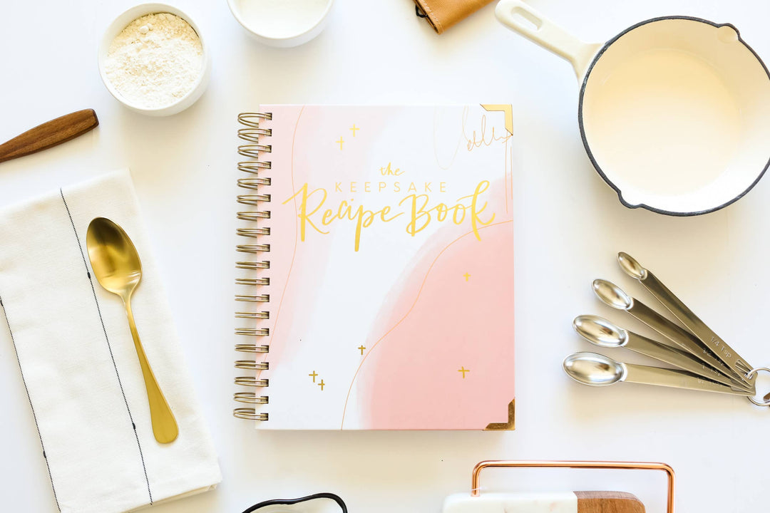 Recipe book with kitchen items on a light surface
