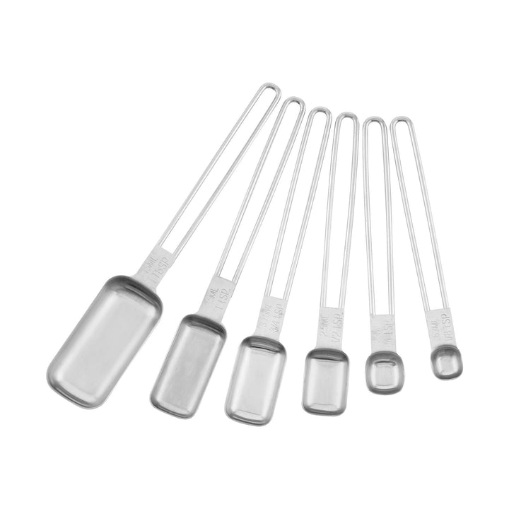 Various sizes of stainless steel measuring spoons on a white background. 