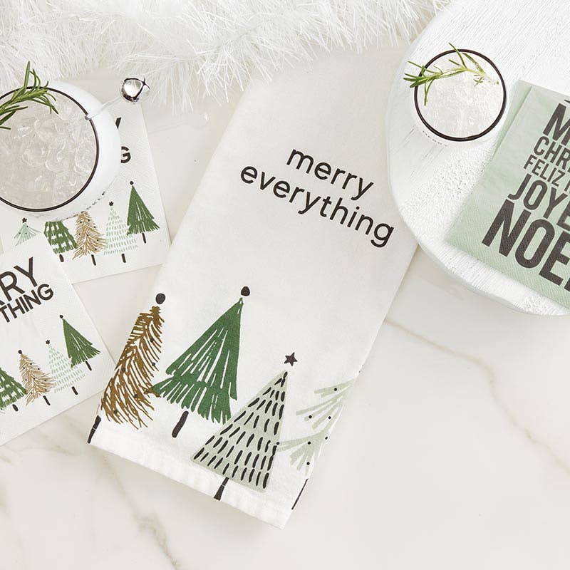 Christmas-themed napkins and a kitchen towel with trees and text on a white surface