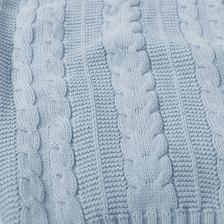 Close-up of a textured light blue fabric with cable knit pattern