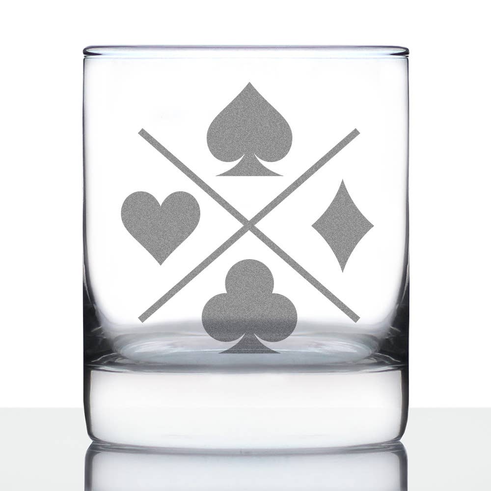 Whiskey rocks glass with playing card suits engraved on a white background