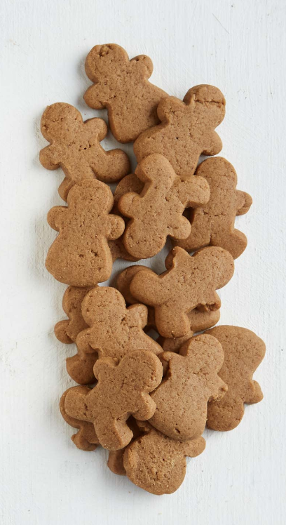 Stack of gingerbread cookies shaped like people on a white background