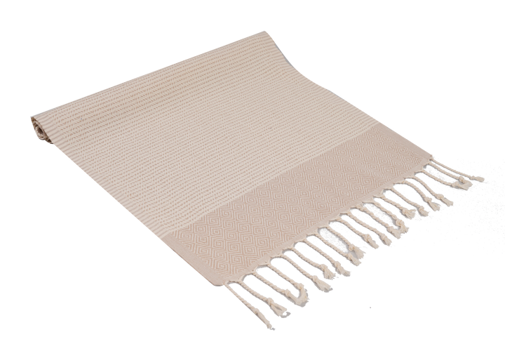 Beige woven blanket with fringes on a white background