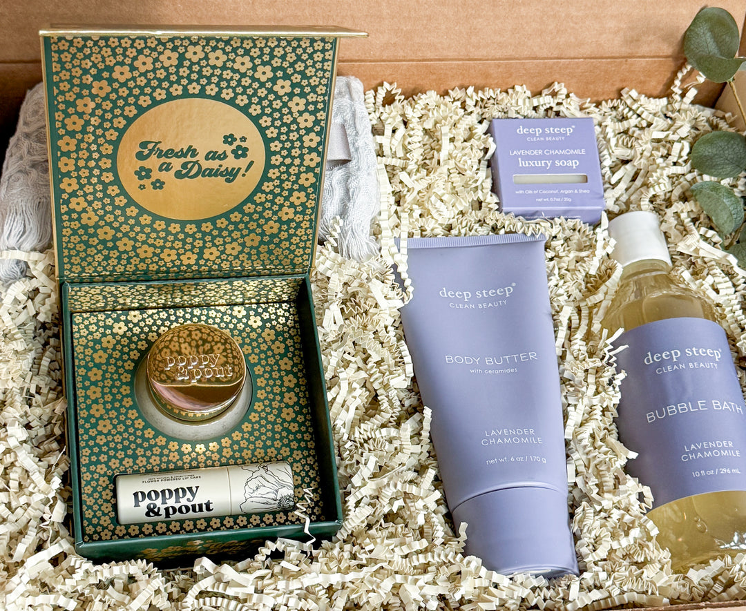 Gift products including bubble bath, body butter, lip balm, lip mask and soap on a textured surface with products with &