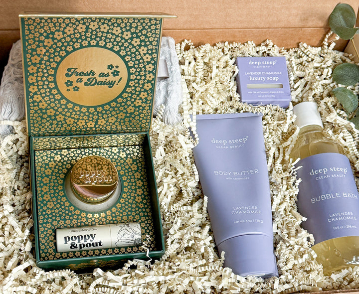 Gift products including bubble bath, body butter, lip balm, lip mask and soap on a textured surface with products with &
