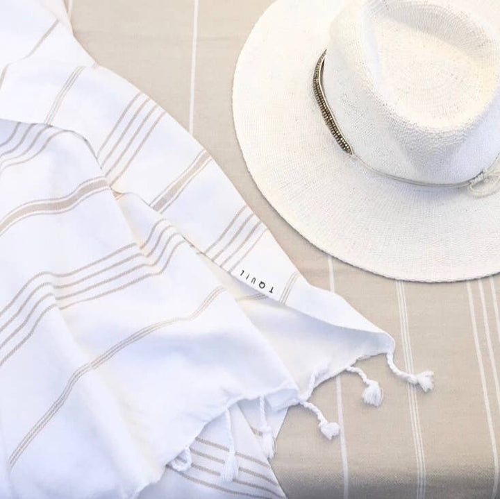 White sun hat and towel with &