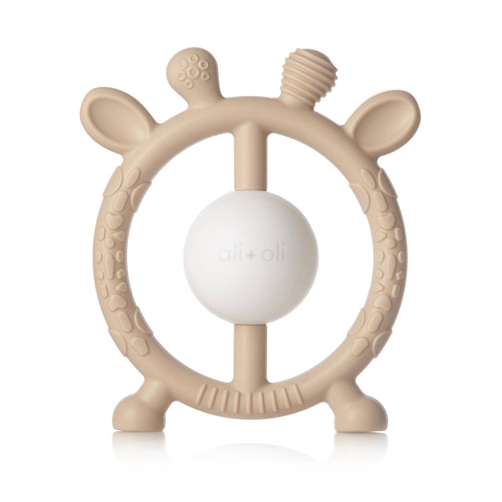 Beige baby teether with a white ball in the center on a white background