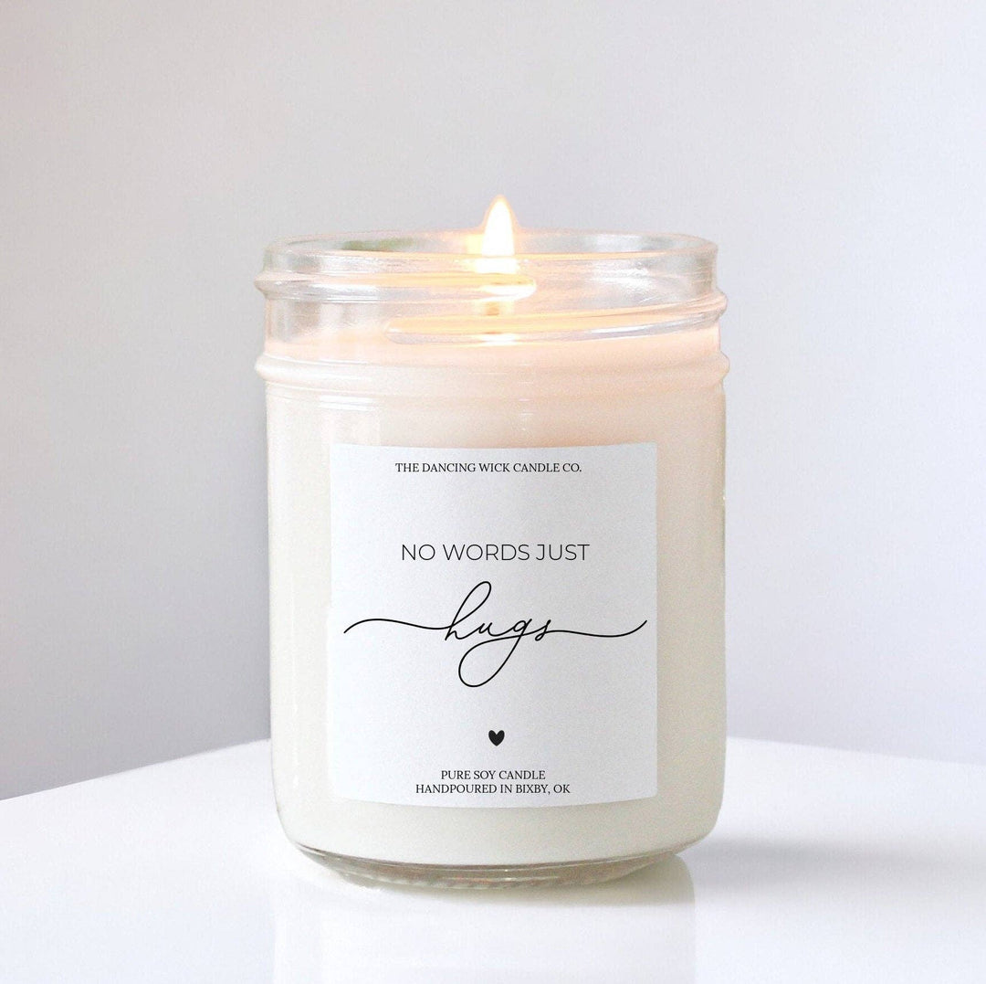Candle in a glass jar with 'No Words Just Hugs' text on a white background