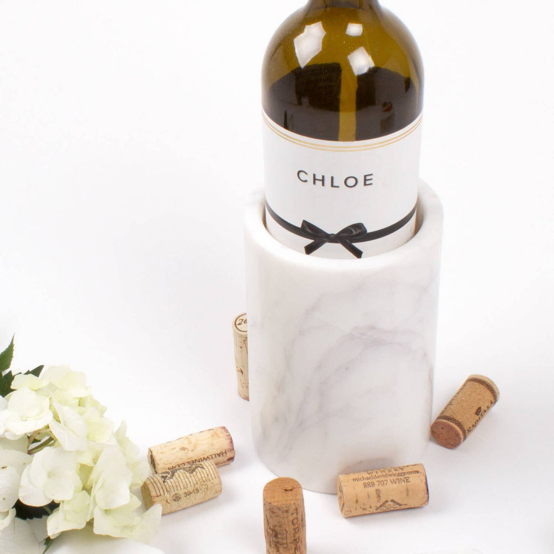 Wine bottle labeled 'CHLOE' with a marble cooler and corks on a white background