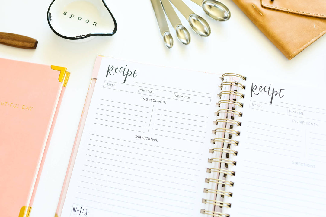 Recipe book with a pen and other items on a white surface