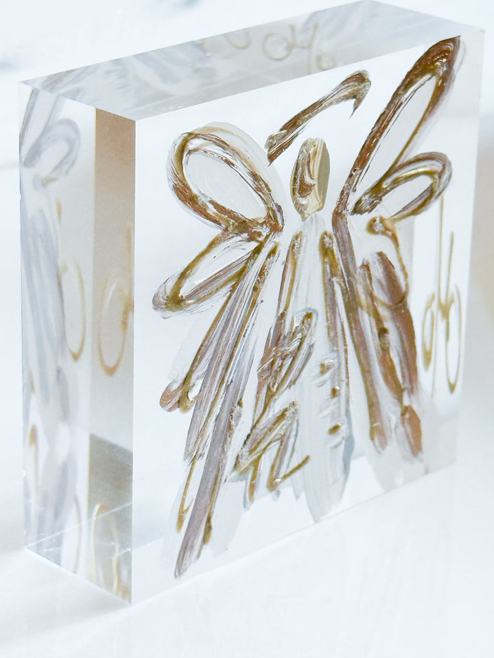 Decorative clear cube with a gold angel design on a white background