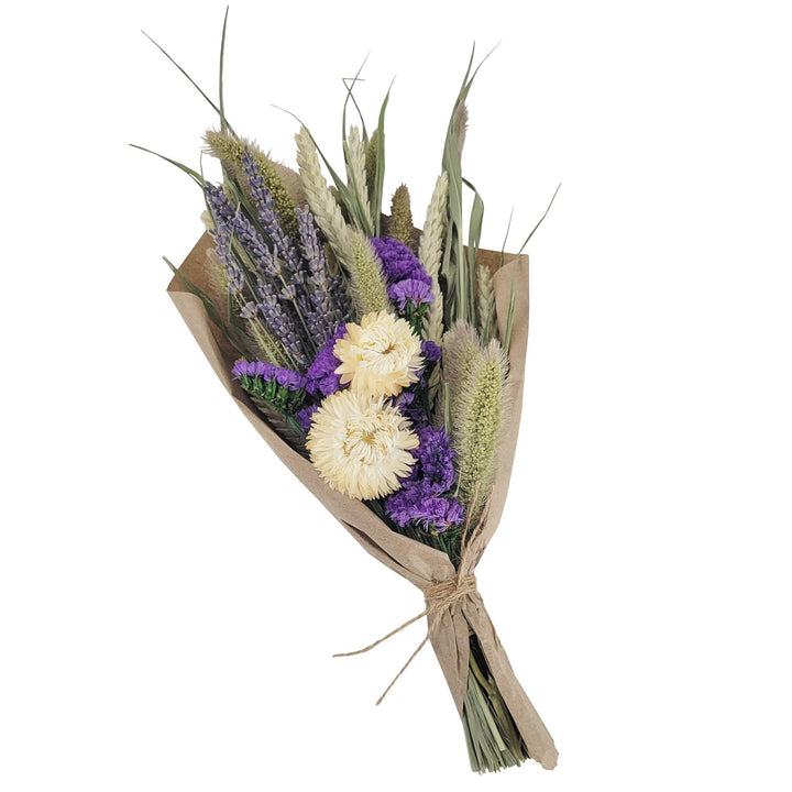 Bouquet of flowers with lavender and greenery wrapped in brown paper on a white background.