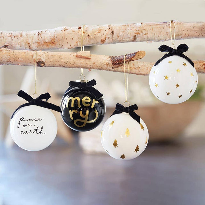 Decorative Christmas ornaments with black bows and text on a branch.