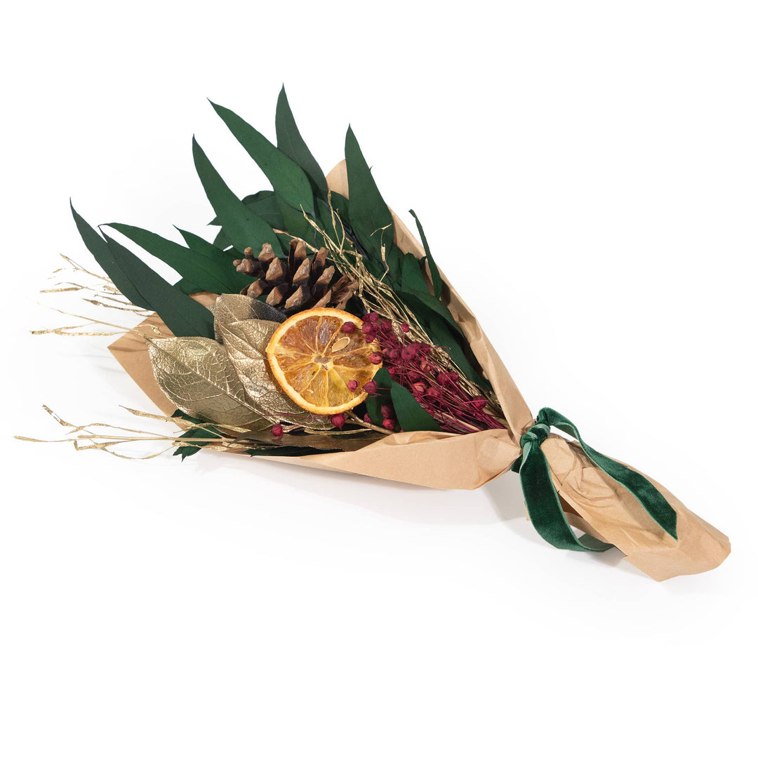 Bouquet of dried flowers and leaves with a slice of orange and pine cone on a white background