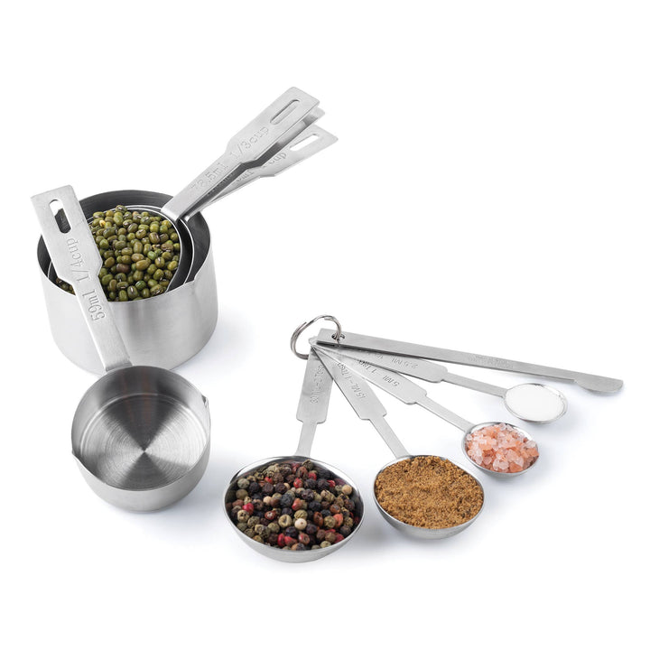 Measuring cups and spoons filled with different ingredients on a white background. 