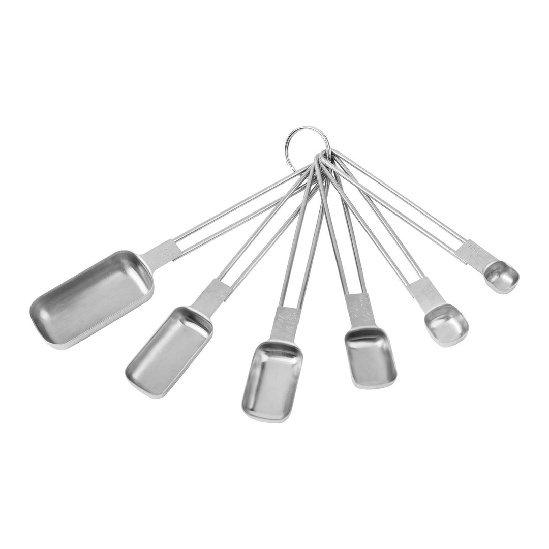 Various sizes of stainless steel measuring spoons on a white background.