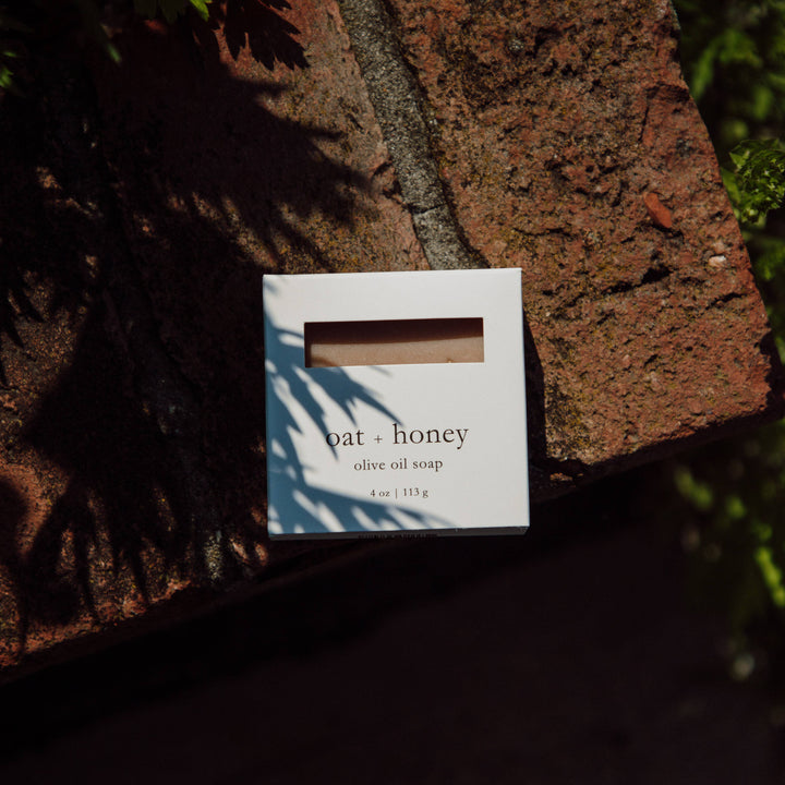 Oat and honey olive oil soap packaging on a stone surface