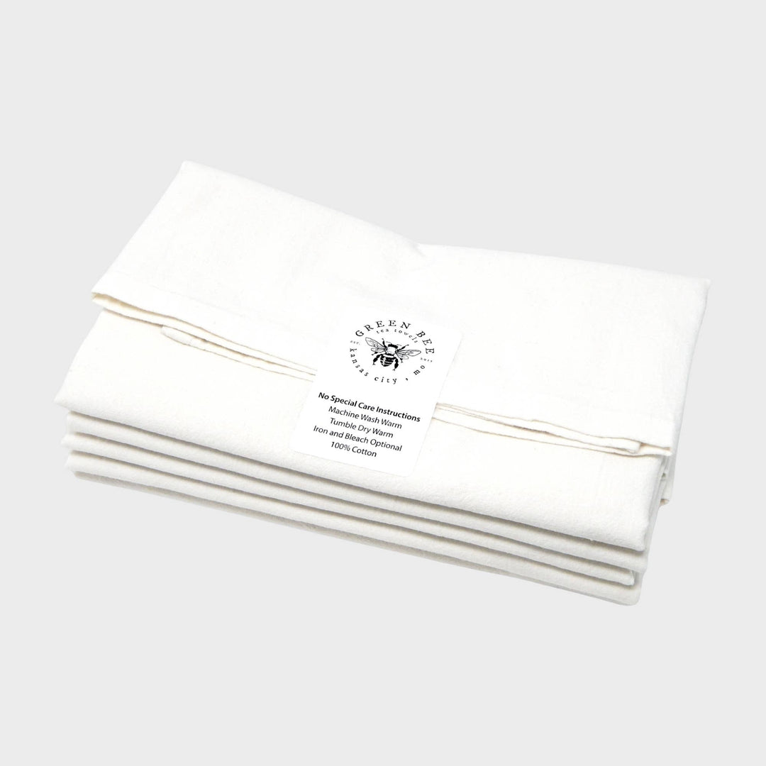 Set of white towels with a brand logo label and text on a light gray background