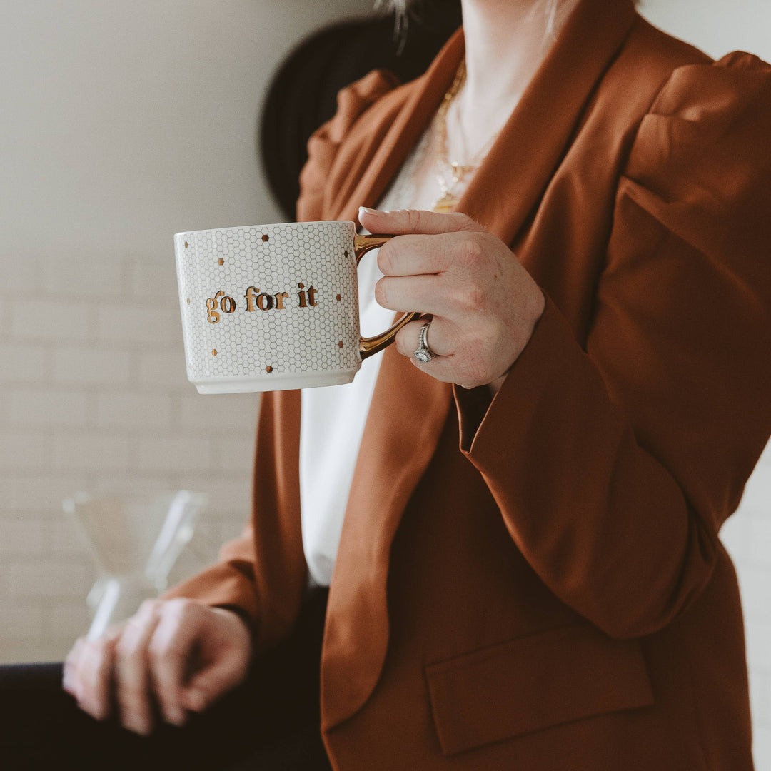 Person holding a mug with &