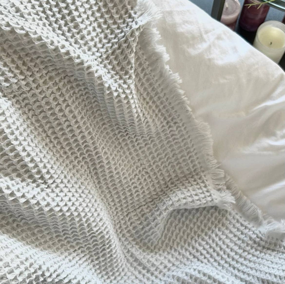 Textured beige blanket with a white garment underneath