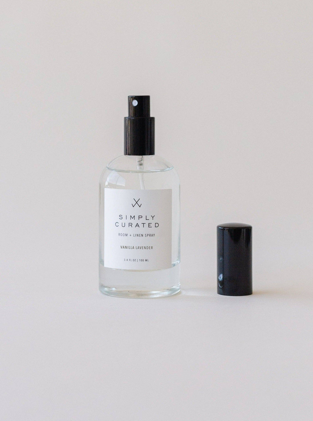 Clear spray bottle with black cap labeled &