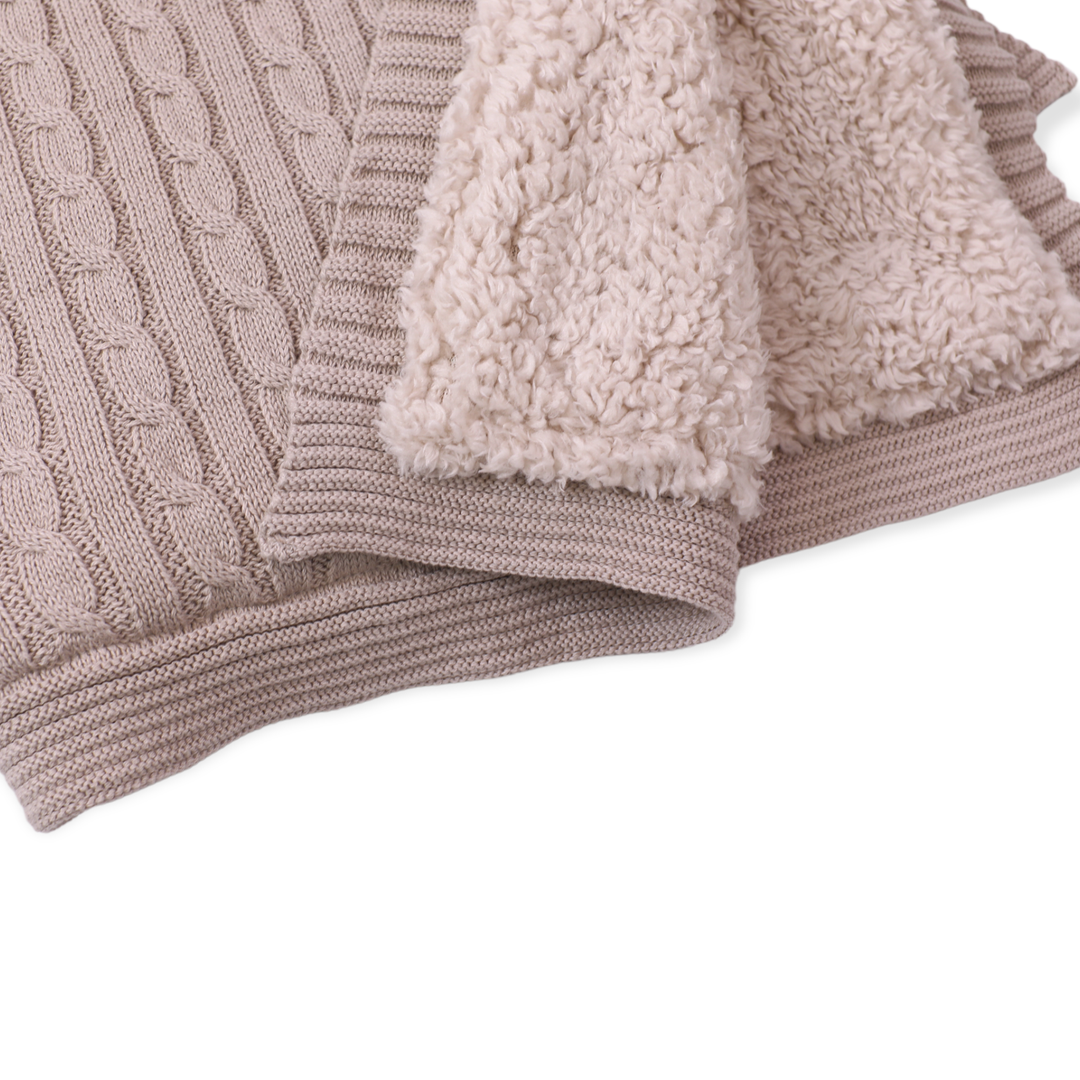 Knitted blanket with textured edge on a white background