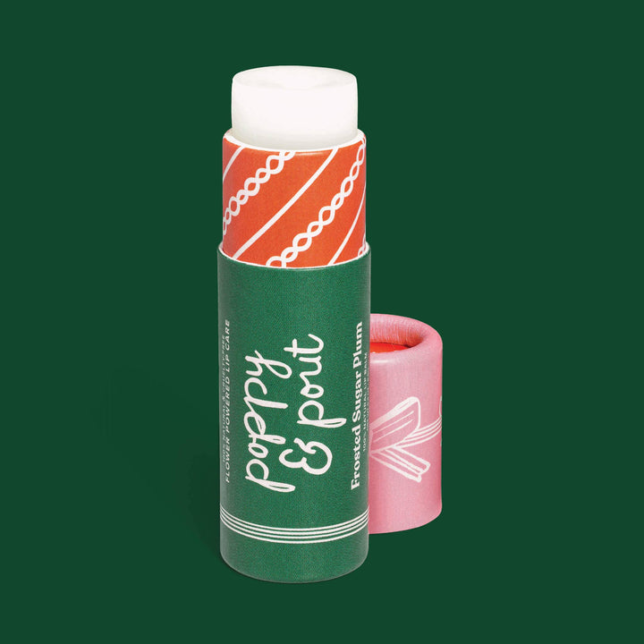 Lip balm with green, pink and red packaging on a green background