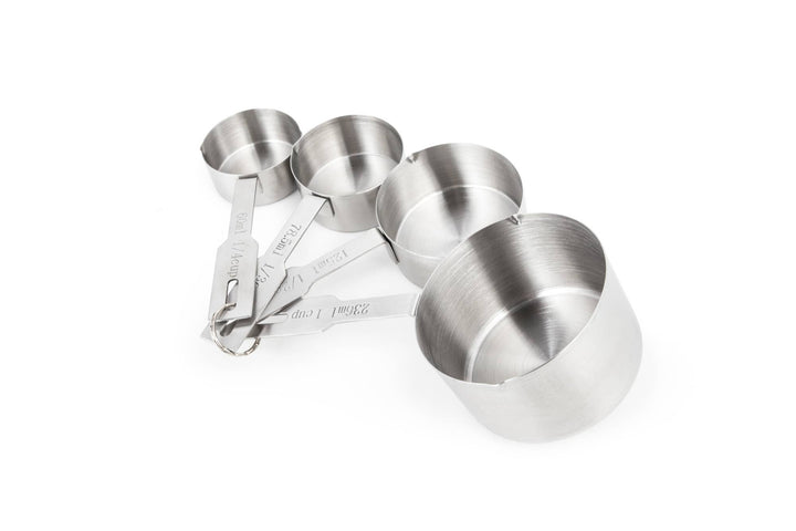 Four different sizes of stainless steel measuring cups connected by a ring on a white background. 