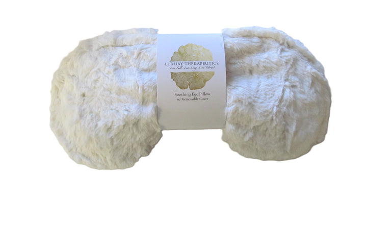 White fluffy eye pillow with a label on a white background
