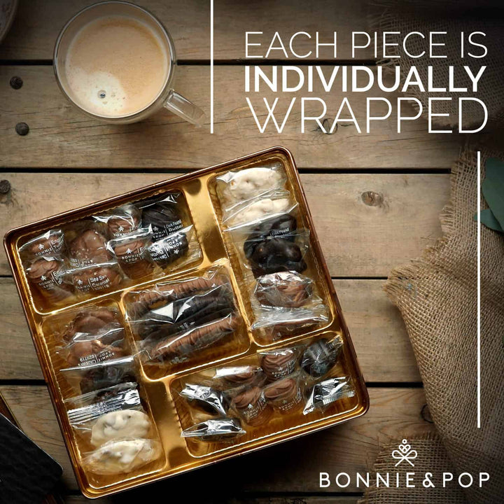 Tray of individually wrapped treats on a wooden surface with a cup of coffee, featuring the brand &