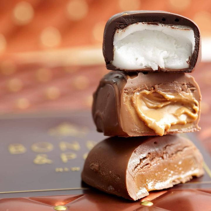 Stack of chocolate-covered treats with visible layers on a blurred background