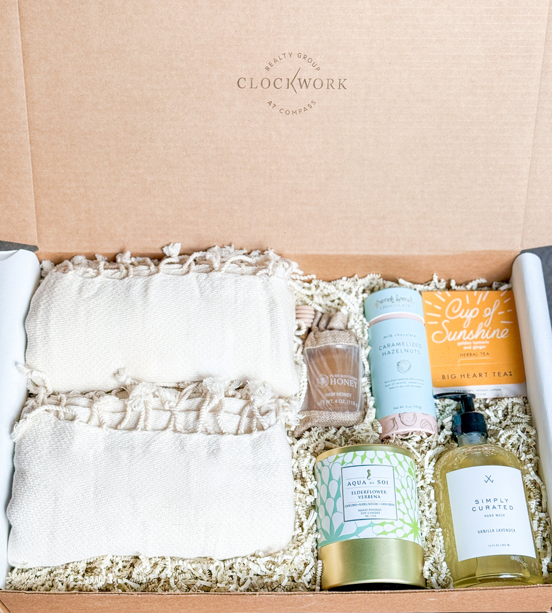 Gift box with a towel, soap, honey, hazelnuts, herbal tea and a candle, featuring the brand &