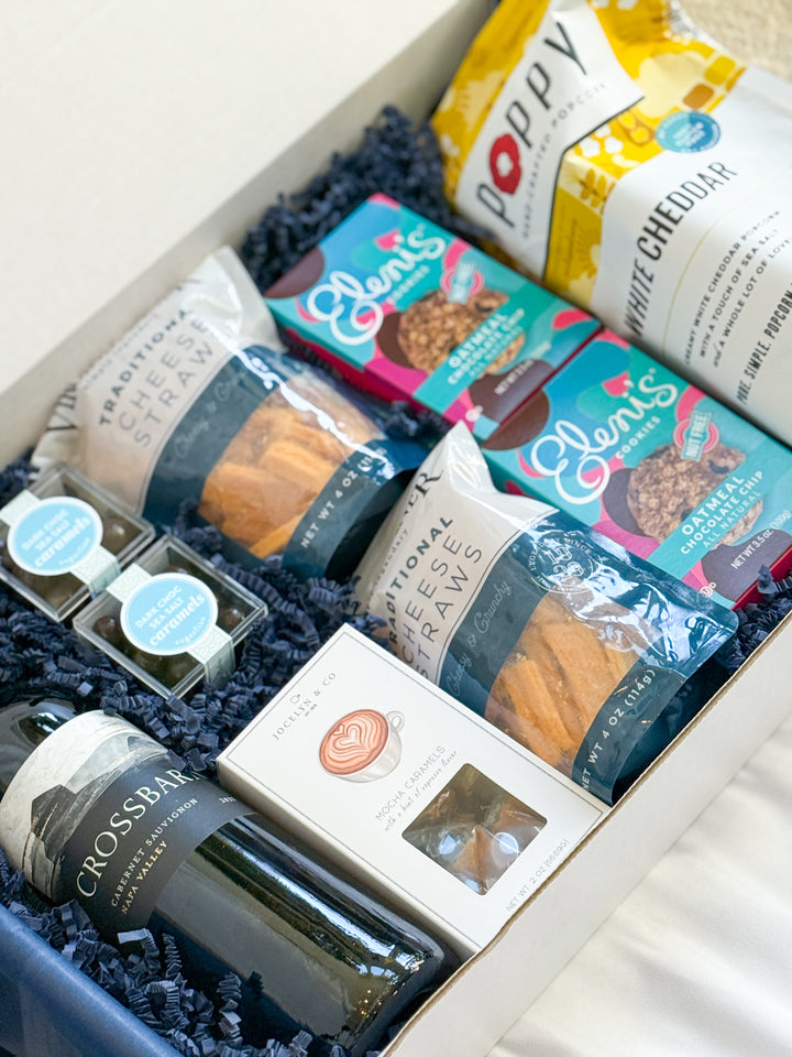 Gourmet gift box with cheese straws snacks, Poppy white cheddar popcorn, mocha caramels, oatmeal cookies, chocolate sea salt caramels and a bottle of Crossbar wine.
