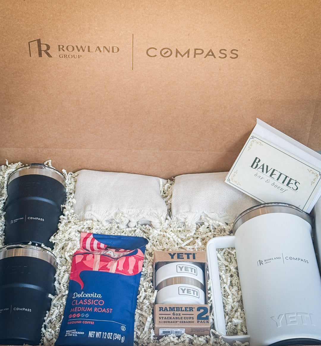 Gift box with Rowland Group and Compass branding, featuring YETI products, ground coffee, blankets and a gift card.