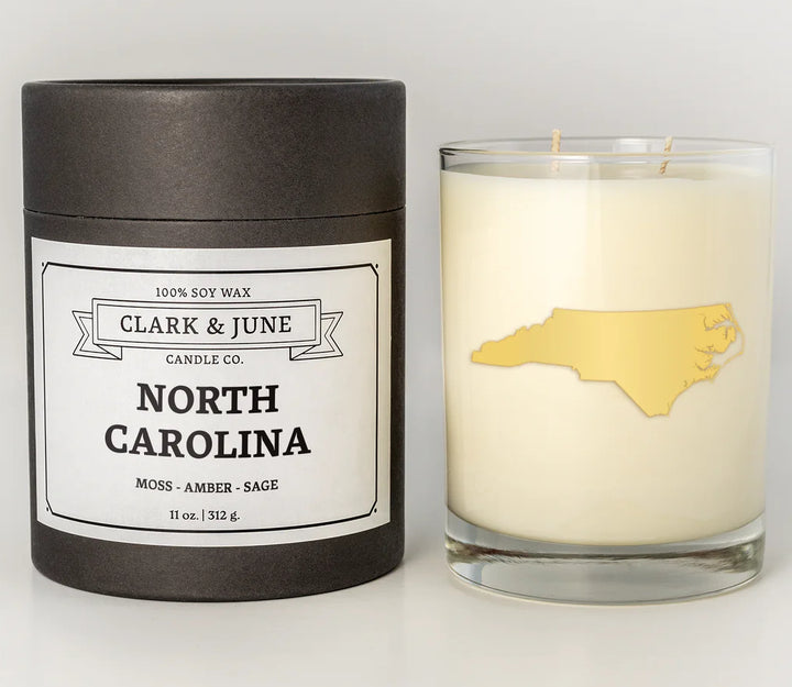 Candle with North Carolina design and Clark &amp; June Candle Co. packaging on a white background