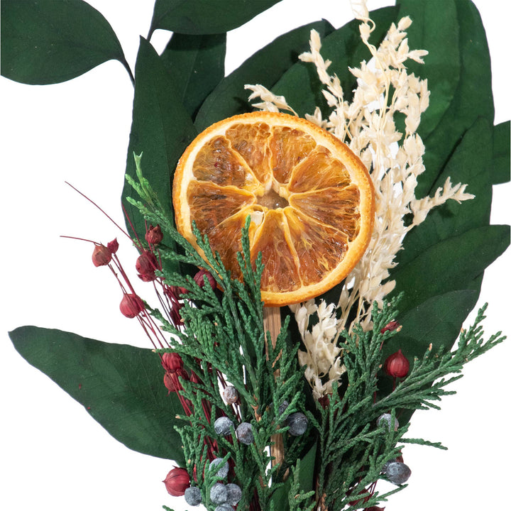 Decorative arrangement with dried orange, green leaves, and berries on a white background