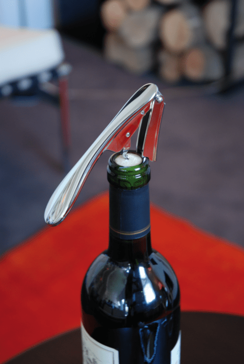 Wine bottle being opened on a red surface